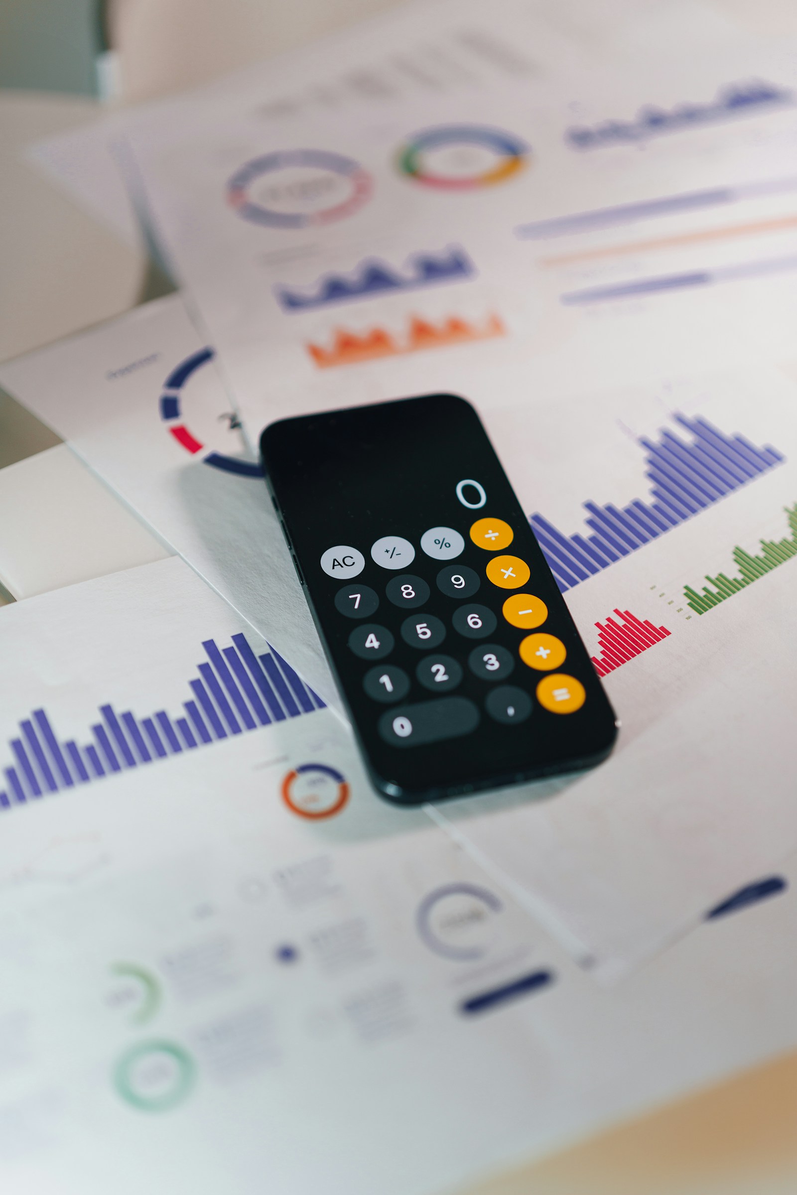 Calculadora digital sobre documentos e gráficos financeiros