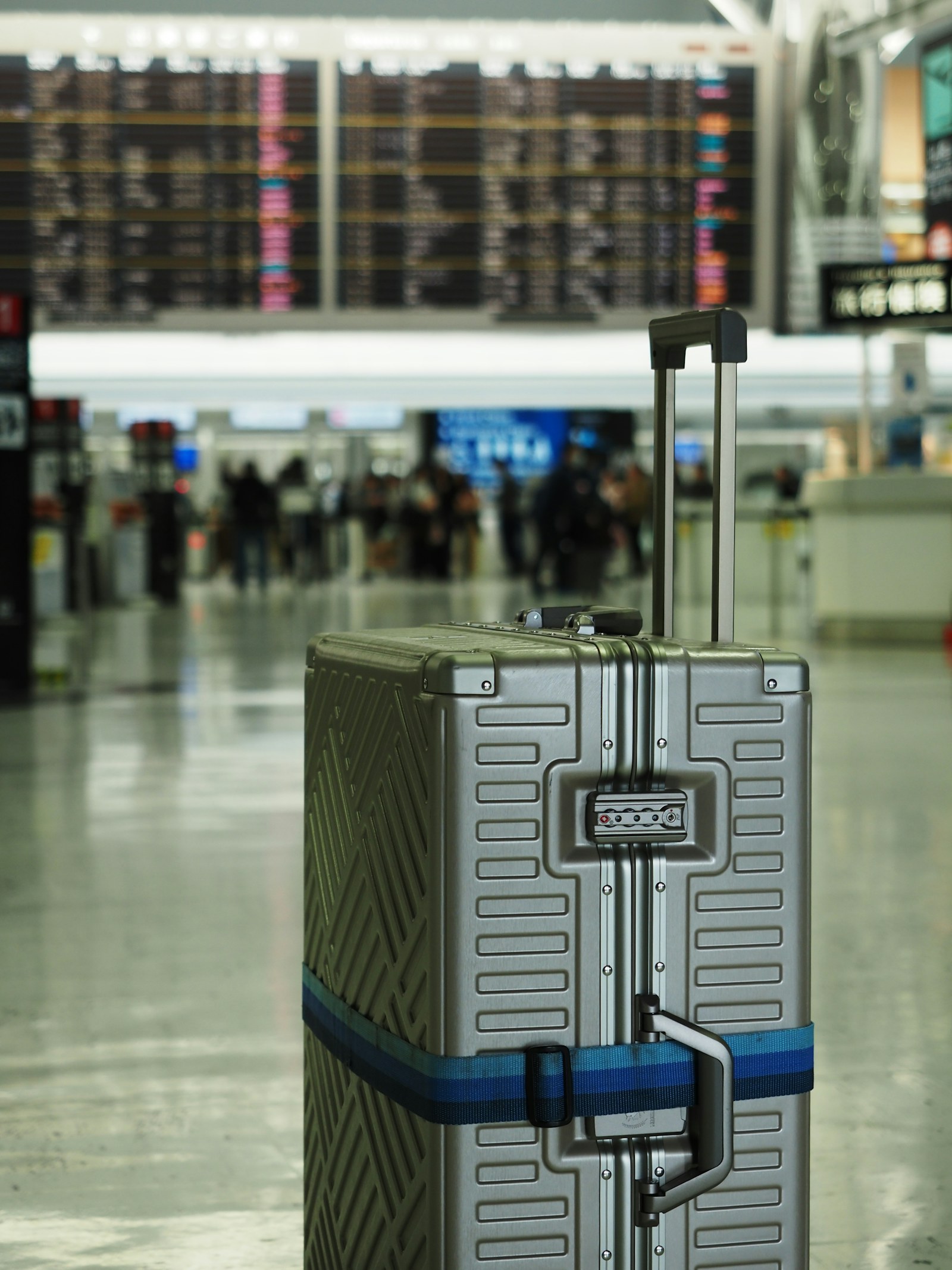Mala diante do painel de voos em um terminal de aeroporto